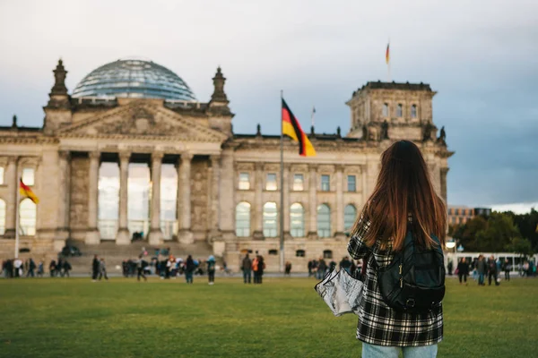 Bir turist kız Almanya'da Berlin Reichstag denilen binanın yanındaki bir sırt çantası ile fotoğraf çeker. Gezi, turizm, seyahat Avrupa