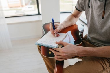 Gitar çalmayı öğrenme. Müzik eğitimi ve ders dışı dersler. Hobiler ve gitar ve şarkı oynamak için coşku.