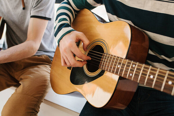 Learning to play the guitar. Music education and extracurricular lessons. Hobbies and enthusiasm for playing guitar and singing songs.