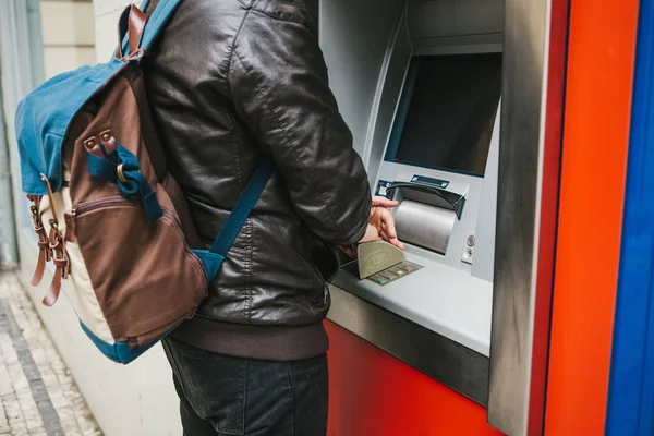 El turista retira dinero del cajero automático para otros viajes. Marca el código con una mano y cierra los botones con la otra mano para proteger la información . — Foto de Stock