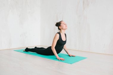 Yoga ve jimnastik yapan genç ve güzel bir kadın. Sağlık konsepti. Tek sporlu dersler.