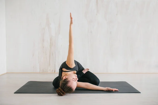 Jonge mooie vrouw die yoga en gymnastiek beoefent. Wellnessconcept. Klassen in één sport. — Stockfoto