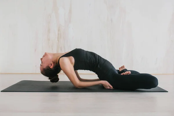 Ung vacker kvinna som utövar yoga och gymnastik. Wellness koncept. Klasser i enskilda sporter. — Stockfoto