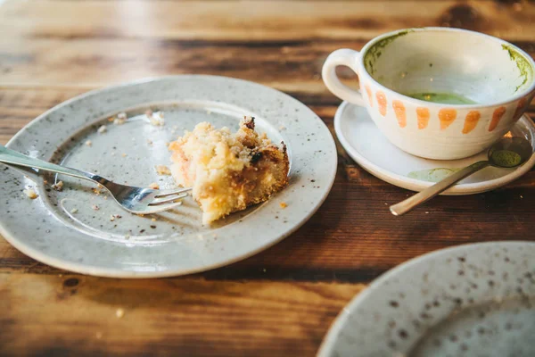 The concept of the completion of the holiday. A dirty plate and an empty cup of coffee. The half-eaten cupcake on a plate. Empty dishes after eating. — Stock Photo, Image