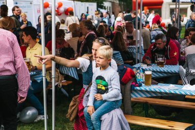 Prag, 23 Eylül 2017: Oktoberfest denilen geleneksel Alman Bira Festivali kutluyor. Güzel bir ulusal kostüm bir anne çocuğunu ilginç bir şey gösterir.