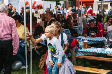 Prag, 23 Eylül 2017: Oktoberfest denilen geleneksel Alman Bira Festivali kutluyor. Güzel bir ulusal kostüm bir anne çocuğunu ilginç bir şey gösterir.