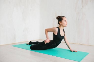 Yoga ve jimnastik yapan genç ve güzel bir kadın. Sağlık konsepti. Tek sporlu dersler.