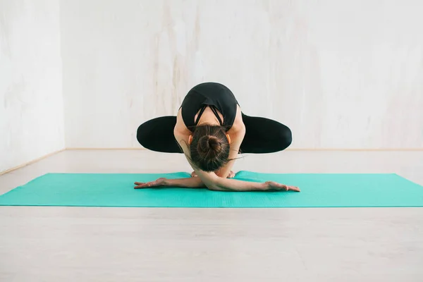 Jonge mooie vrouw die yoga en gymnastiek beoefent. Wellnessconcept. Klassen in één sport. — Stockfoto