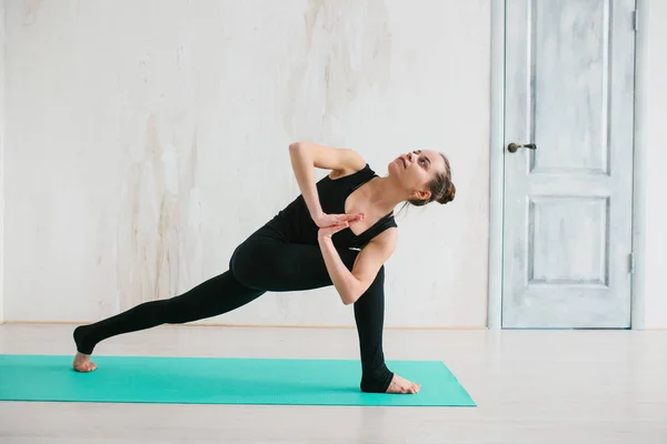 Jonge mooie vrouw die yoga en gymnastiek beoefent. Wellnessconcept. Klassen in één sport. — Stockfoto