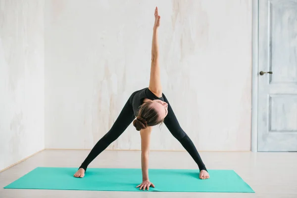 Jonge mooie vrouw die yoga en gymnastiek beoefent. Wellnessconcept. Klassen in één sport. — Stockfoto