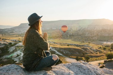 Pratik Yoga üst kısmındaki Kapadokya dağ güneş doğarken genç güzel kız. Gevşeme uygulamaları.