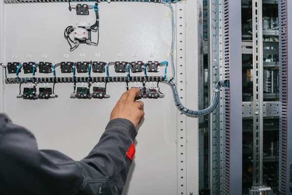 Electrician specialist checking low-voltage cabinet equipment