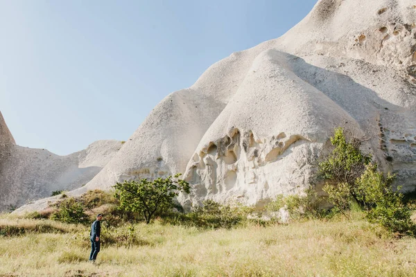 Człowiek stoi obok pięknych skał i podziwia krajobraz w Kapadocji w Turcji. Krajobraz Kapadocji. Wzgórza. — Zdjęcie stockowe