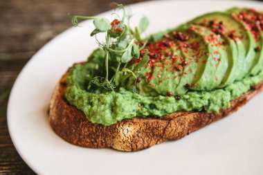 Bir plaka üzerinde avokado sandviç. Lezzetli ve sağlıklı diyet gıda.