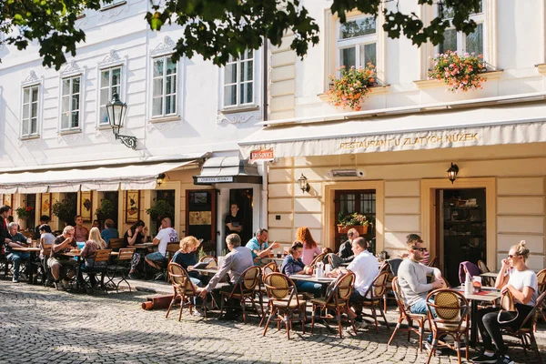 Praga, 29 de septiembre de 2017: Un popular café callejero cerca del Puente de Carlos. Residentes locales y turistas descansan, comen y se comunican en un día soleado y cálido . — Foto de Stock