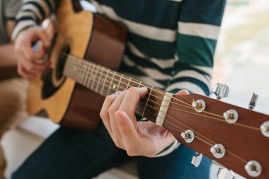 Gitar çalmayı öğrenme. Müzik eğitimi ve ders dışı dersler. Hobiler ve gitar ve şarkı oynamak için coşku.