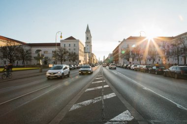 Yolun bir bakış, Münih - Almanya Bavyera'da başkenti sokak Leopoldstrasse üzerinde. Hızlı hareket araba günbatımı arka plan üzerinde bulanık.