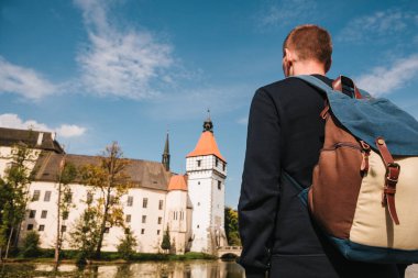 Bir sırt çantası ile bir turistik yerler görünüyor. Blatna Çek Cumhuriyeti'nde aradım Kalesi arka planda bulanık. Tatil, seyahat.