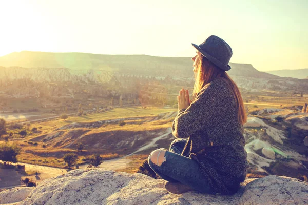 Jovem menina bonita praticando ioga no topo de uma montanha na Capadócia ao nascer do sol. Práticas de relaxamento . — Fotografia de Stock