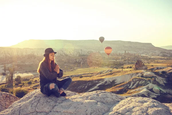 Mooi meisje beoefenen van yoga op de top van een berg in Cappadocië bij zonsopgang. Praktijken van ontspanning. — Stockfoto