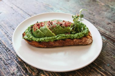 Bir plaka üzerinde avokado sandviç. Lezzetli ve sağlıklı diyet gıda.