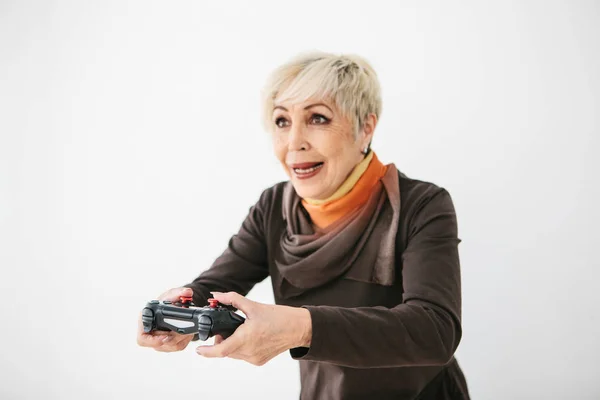 An elderly woman plays a video game and gestures that she won. Elderly person and modern technology. — Stock Photo, Image