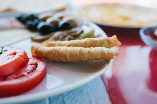 Szczelnie-do góry. Śniadanie na talerzu składający się z pomidora, sera, rolki, czarne i zielone oliwki i bakłażana. — Zdjęcie stockowe