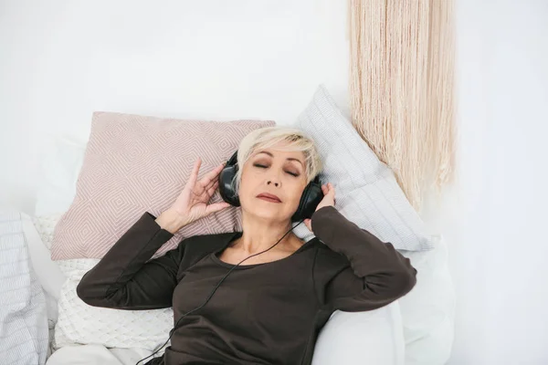 Pozytywne starszą kobietę słuchania muzyki. Starszego pokolenia i nowych technologii. — Zdjęcie stockowe