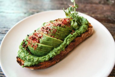 Bir plaka üzerinde avokado sandviç. Lezzetli ve sağlıklı diyet gıda.