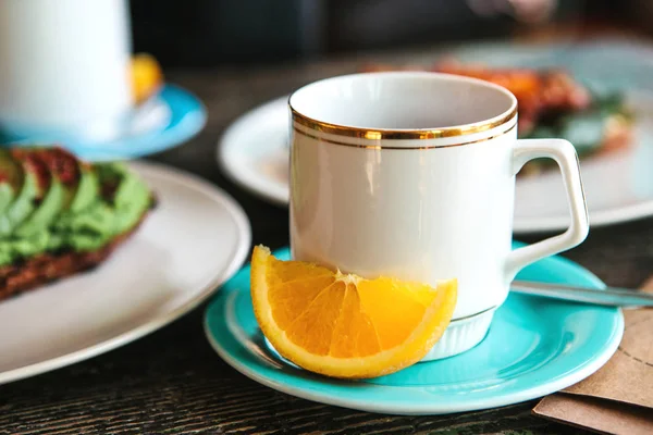Чашка ароматного полезного вкусного чая с апельсиновым ломтиком поблизости. Полезный и вкусный завтрак . — стоковое фото