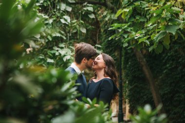 Sevgi dolu genç güzel bir çift sarılma ve öpüşme parkta ağaçların arasında öğrencilerin Avrupa'dan. Hisler ve duygular insanlar arasında kapatın.