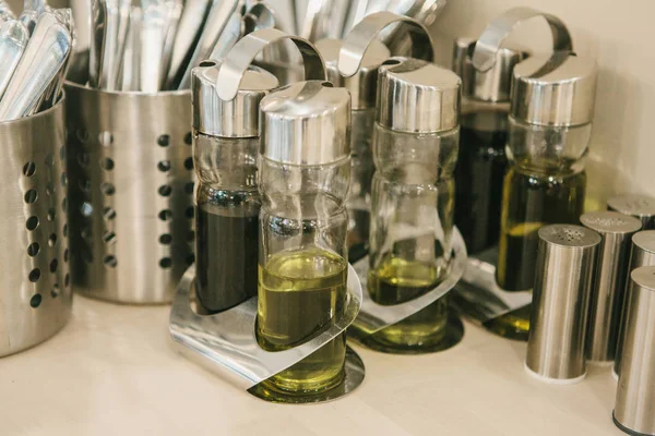 Sporo różnych przypraw i olejów w specjalnych pojemnikach stoją na stole — Zdjęcie stockowe