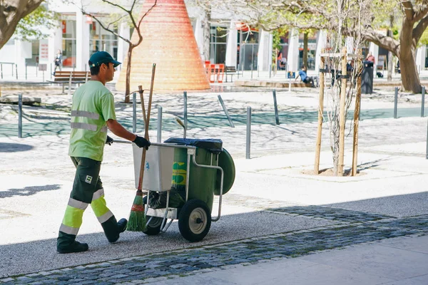 Lisbon, April 25, 2018: A professional cleaner works on a city street. Cleaning the territory and taking care of ecological well-being. — Stock Photo, Image