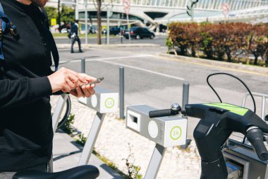 Erkek bir turist bir bisiklet veya bir mobil uygulama telefonunu kullanarak ulaşım alternatif bir çevre modu işe alır. Ya da sadece bir sayı ve aramalar aramalar veya Internet sokakta kullanır.