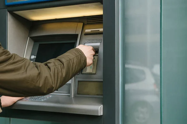 De toerist trekt geld uit de geldautomaat voor verdere reizen. Grijpt een kaart uit de Atm. Finance, de creditcard, de terugtrekking van geld. — Stockfoto