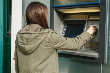 Genç bir kadın bir Atm. çekimden para Atm. finans, kredi kartı, para çekilmesi kartından alır..