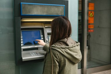 Genç bir kadın bir Atm. çekimden para Atm. finans, kredi kartı, para çekilmesi kartından alır..