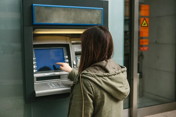 Молодая женщина берет деньги в банкомате. Схватил карту из банкомата. Финансы, кредитная карта, снятие денег . — стоковое фото