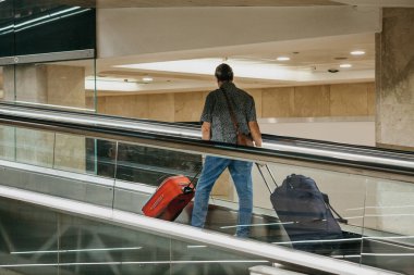 Yürüyen merdivende giden bir turist.