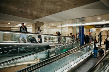 Milano 'daki tren istasyonunda bir sürü insan yürüyen merdiveni kullanıyor..
