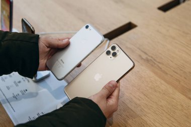 Türkiye, İstanbul, 17 Aralık 2019: Alıcı, eski iPhone 'daki kamera ile Apple mağazasındaki en son modern iPhone 11' i karşılaştırıyor.
