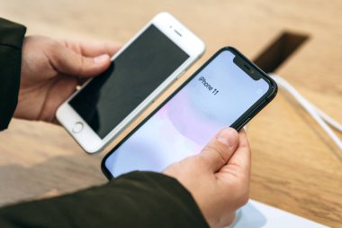 Türkiye, İstanbul, 17 Aralık 2019: Alıcı, eski iPhone 'daki kamera ile Apple mağazasındaki en son modern iPhone 11' i karşılaştırıyor.