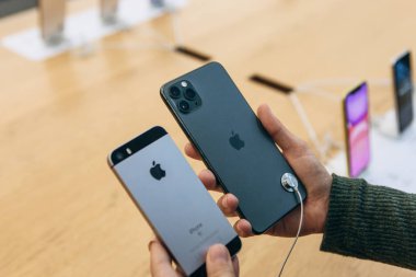 Türkiye, İstanbul, 17 Aralık 2019: Alıcı, eski iPhone 'daki kamerayla Apple mağazasındaki en son modern iPhone 11' i karşılaştırıyor
