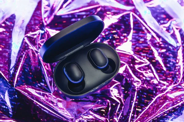 The wireless headphones in the box are unpacked on a trendy neon color or gradient background. — 스톡 사진