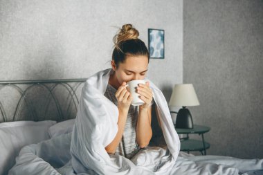Girl drinks a drink from a mug