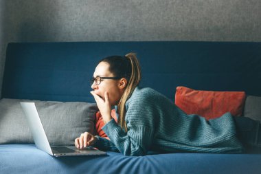 Kız dizüstü bilgisayarda çalışırken esniyor.