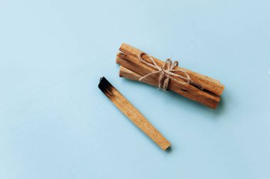 Palo Santo mavi bir arka plan üzerine yapışır. Aromaterapi ve dini törenlere ve meditasyon kullanılan.