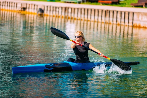 Female athlete in kayak on lake