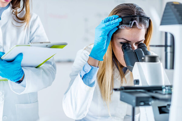 Female biotechnology scientists working in laboratory