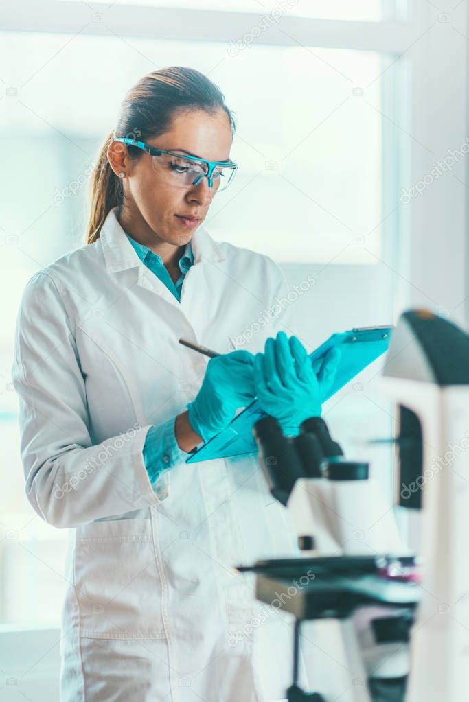 Biotechnology scientist taking notes